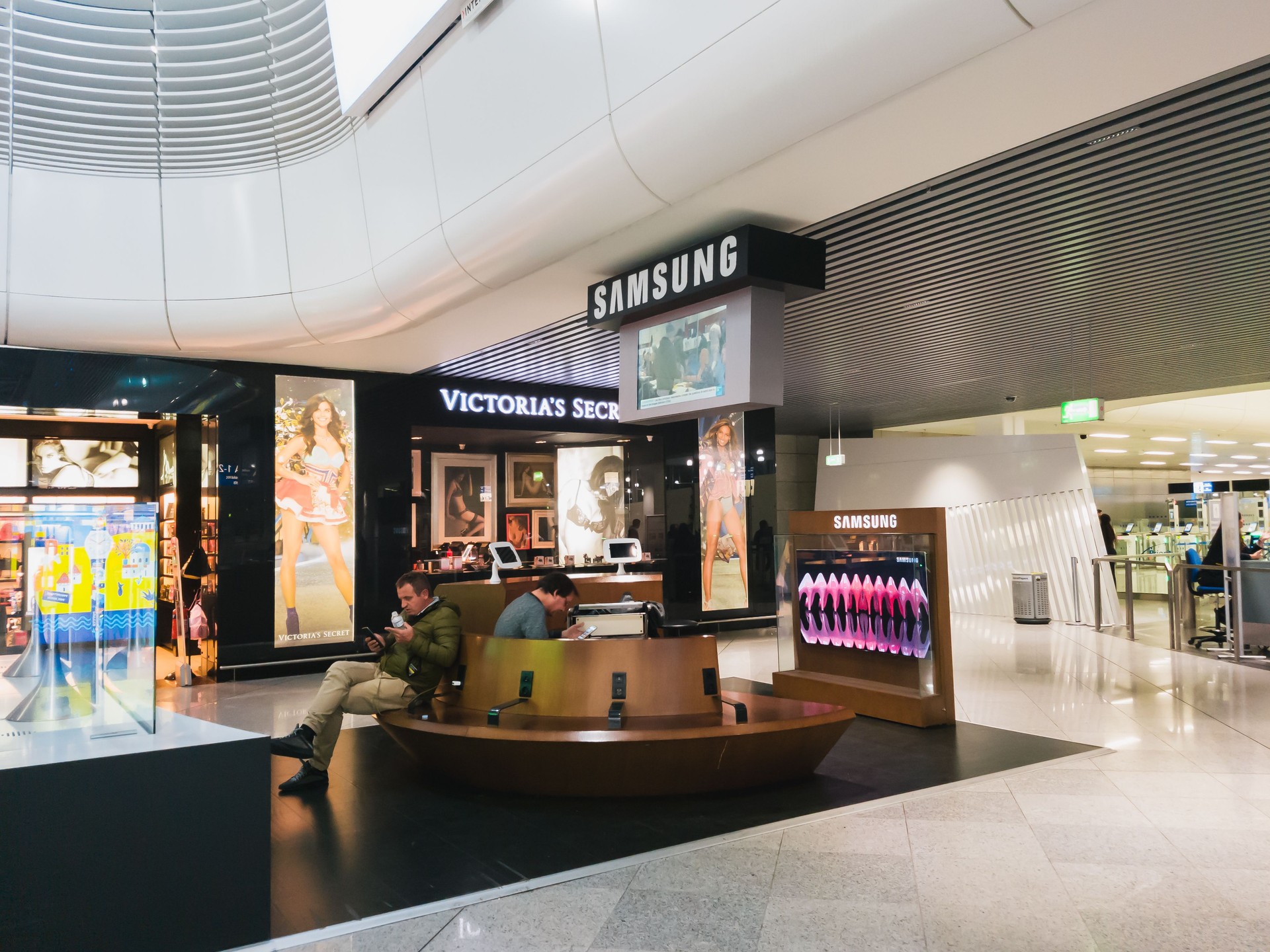 People sitting at a charging station for mobile devices from Samsung inside the departure hall of Athens International Airport Eleftherios Venizelos. Recharging mobile phones from free charge station at the airport